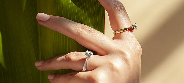 Dwa pierścionki z białego i żółtego złota z diamentami syntetycznymi YES Responsible Diamond ukazane na dłoni.